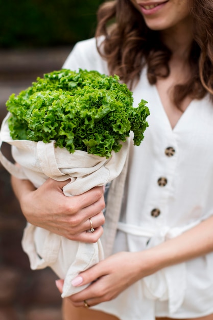 Gratis foto jonge vrouw met boodschappen tas