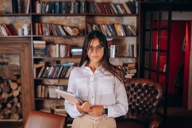 Jonge vrouw met documenten in handen voor een boekenplank