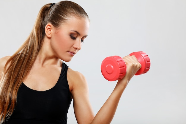 Jonge vrouw met dumbells