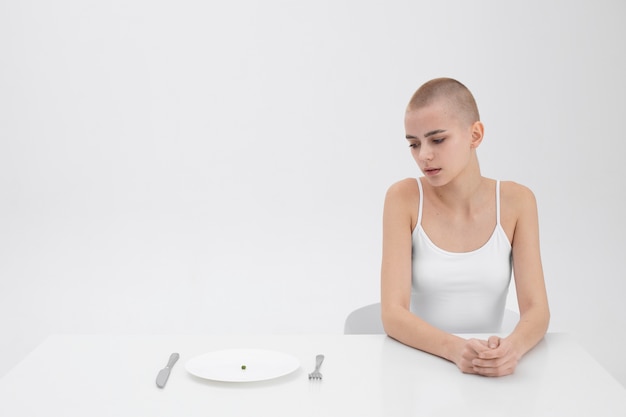 Jonge vrouw met een eetstoornis die een erwt wil eten