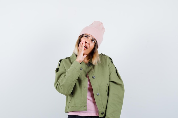 Jonge vrouw met een jas en een roze hoed