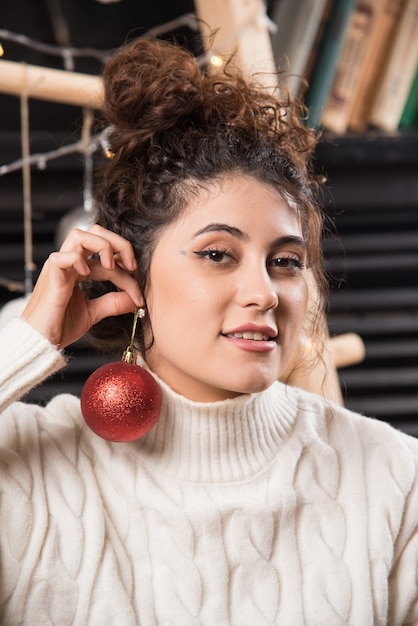 Jonge vrouw met een rode kerstbal