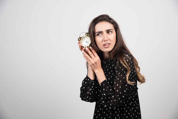 Jonge vrouw met een wekker