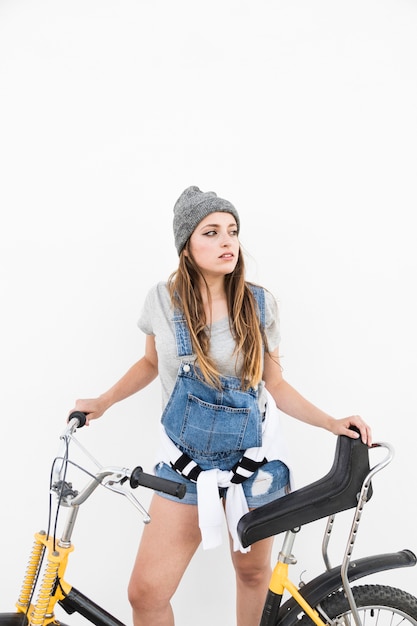 Jonge vrouw met fiets tegen witte achtergrond