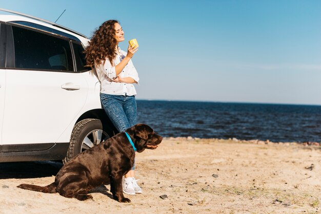 Jonge vrouw met haar hond op het strand