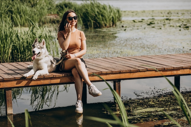 Jonge vrouw met haar husky hond aan het meer