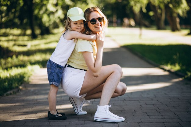 Jonge vrouw met kleine dochter die in park loopt