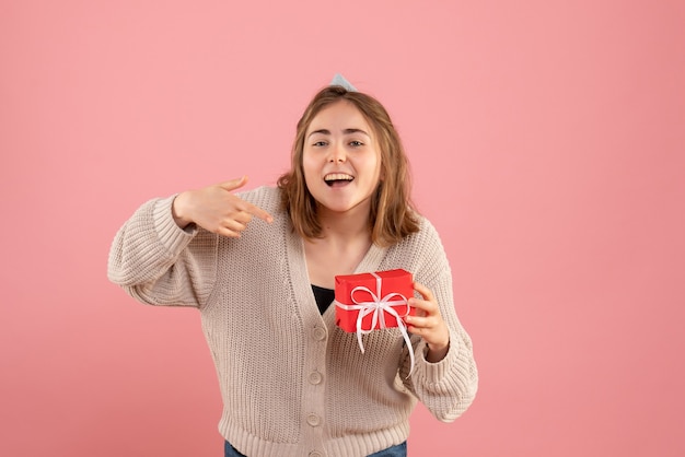 jonge vrouw met kleine kerst aanwezig op roze