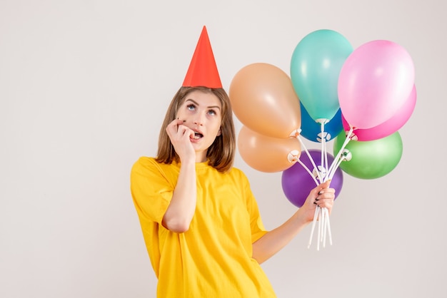 jonge vrouw met kleurrijke ballonnen en dromen op wit