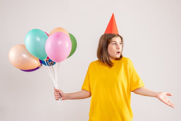 jonge vrouw met kleurrijke ballonnen op wit