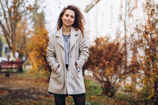 Jonge vrouw met krullend haar in park