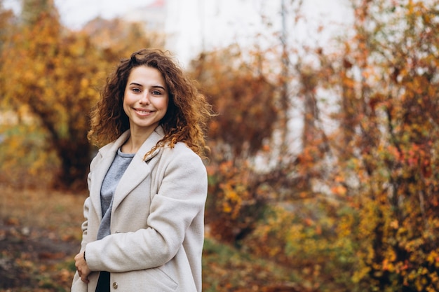 Jonge vrouw met krullend haar in park