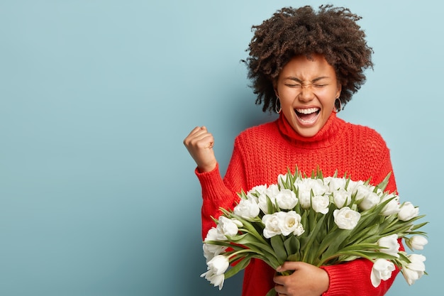 Jonge vrouw met krullend haar met boeket van witte bloemen