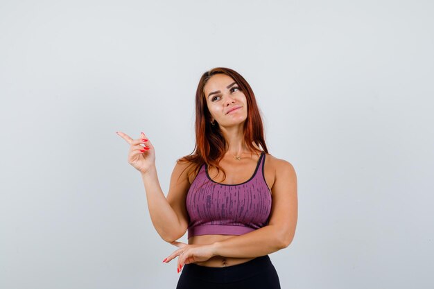 Jonge vrouw met lang haar die sportkleding draagt