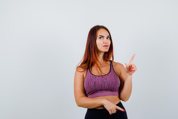 Jonge vrouw met lang haar die sportkleding draagt