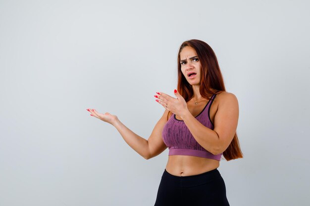 Jonge vrouw met lang haar die sportkleding draagt