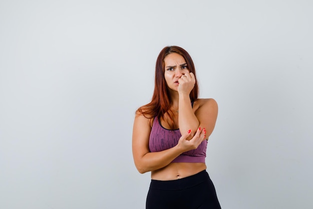 Jonge vrouw met lang haar die sportkleding draagt