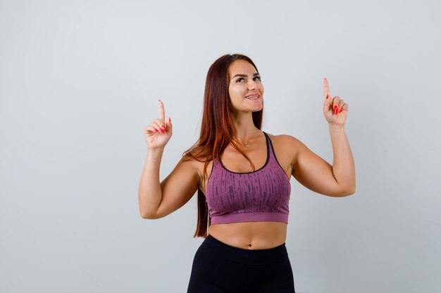 Jonge vrouw met lang haar die sportkleding draagt