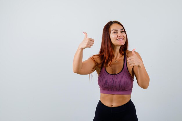 Jonge vrouw met lang haar die sportkleding draagt