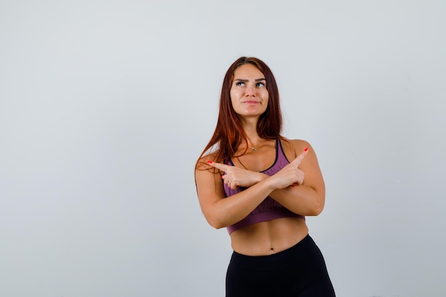 Jonge vrouw met lang haar die sportkleding draagt