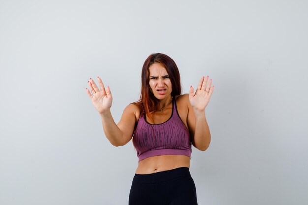 Jonge vrouw met lang haar die sportkleding draagt