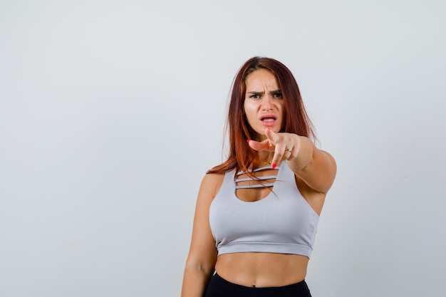 Jonge vrouw met lang haar die sportkleding draagt