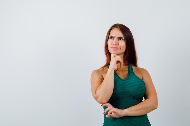 Jonge vrouw met lang haar, gekleed in een groene bodycon