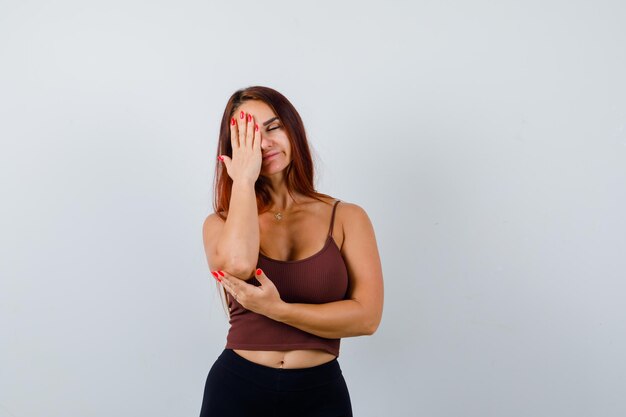 Jonge vrouw met lang haar in een bruine crop top