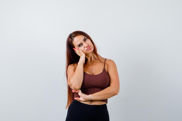 Jonge vrouw met lang haar in een bruine crop top