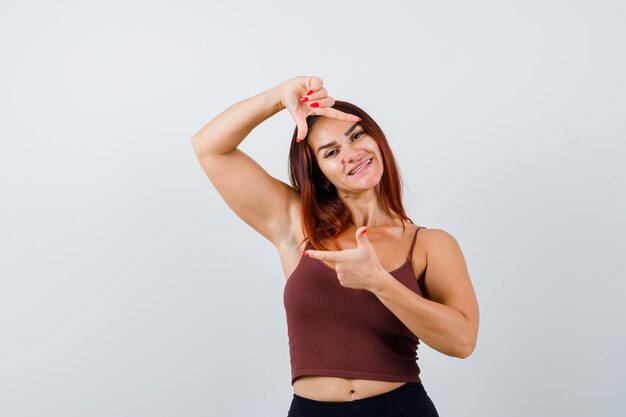 Gratis foto jonge vrouw met lang haar in een bruine crop top