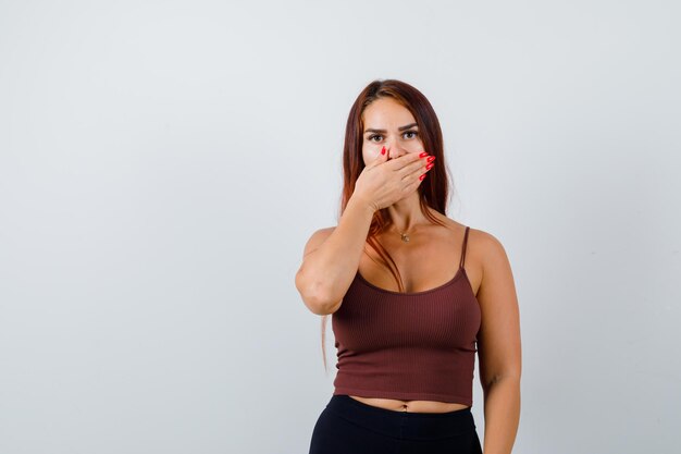 Jonge vrouw met lang haar in een bruine crop top