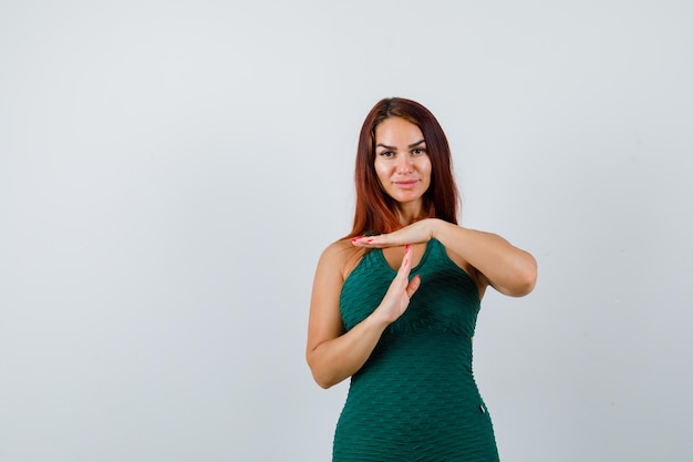 Jonge vrouw met lang haar in een groene bodycon