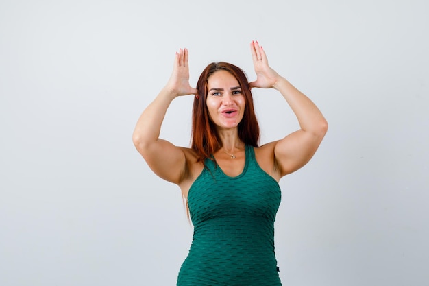 Jonge vrouw met lang haar in een groene bodycon