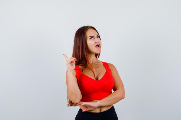 Jonge vrouw met lang haar in een oranje tanktop