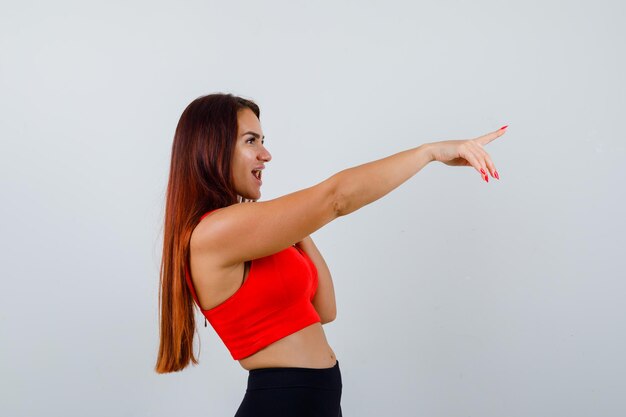 Jonge vrouw met lang haar in een oranje tanktop