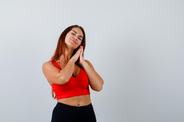 Jonge vrouw met lang haar in een oranje tanktop