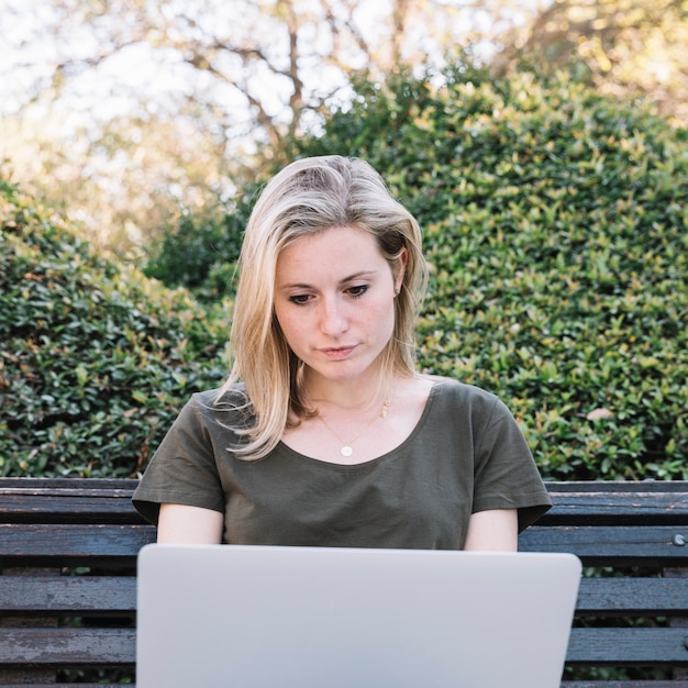 Jonge vrouw met laptop op de bank