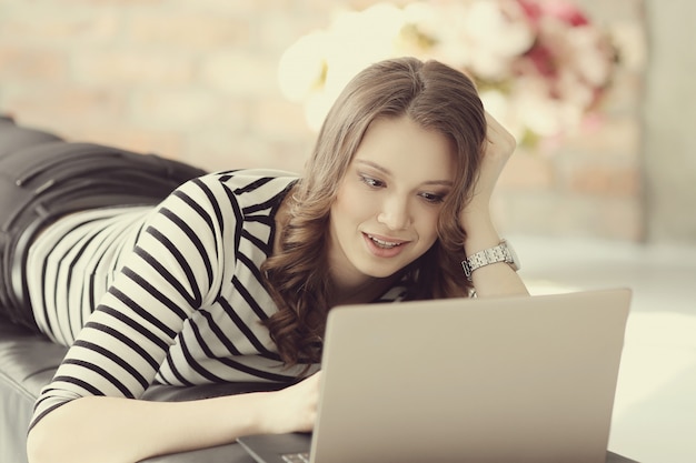 Jonge vrouw met laptop pc-computer