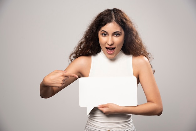 Jonge vrouw met lege lege witte toespraak poster. Hoge kwaliteit foto