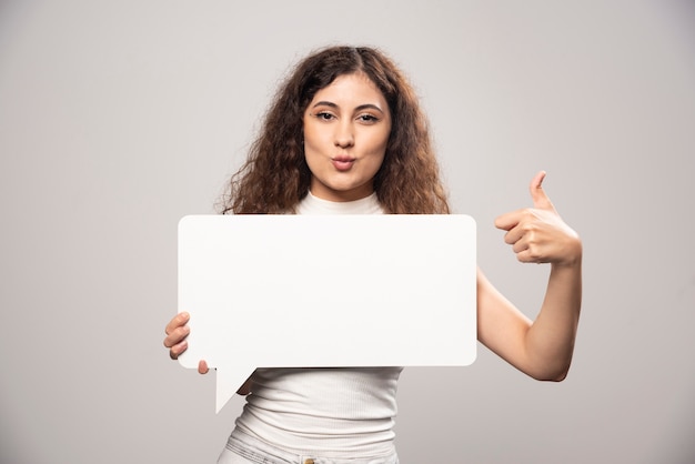 Jonge vrouw met lege lege witte toespraak poster. Hoge kwaliteit foto