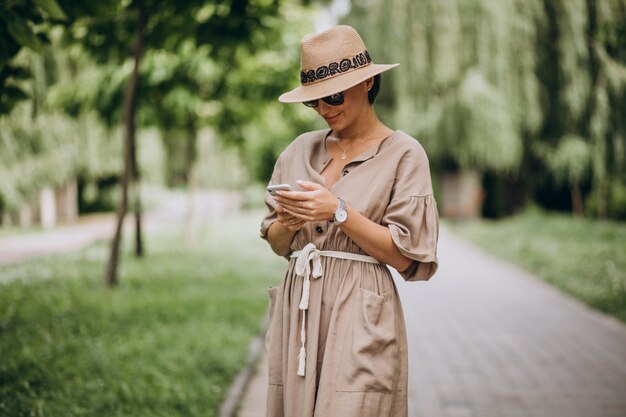 Jonge vrouw met mobiele telefoon in park