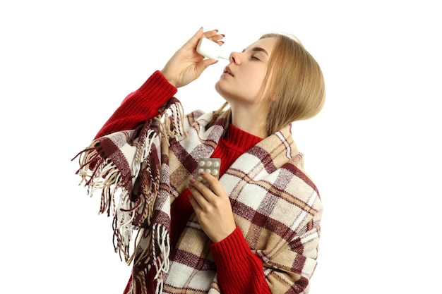 Jonge vrouw met neusspray geïsoleerd op witte achtergrond