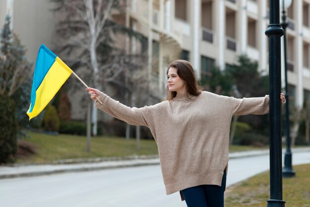 Jonge vrouw met oekraïense vlag medium shot