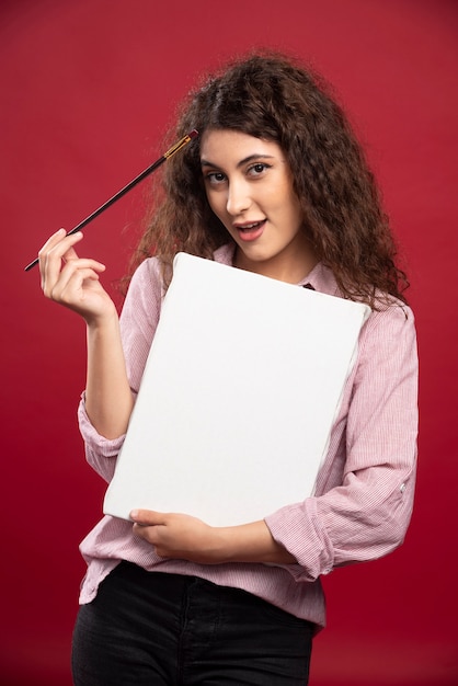 Jonge vrouw met penseel en canvas.