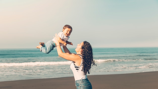 Jonge vrouw met plezier met baby op zomer strand