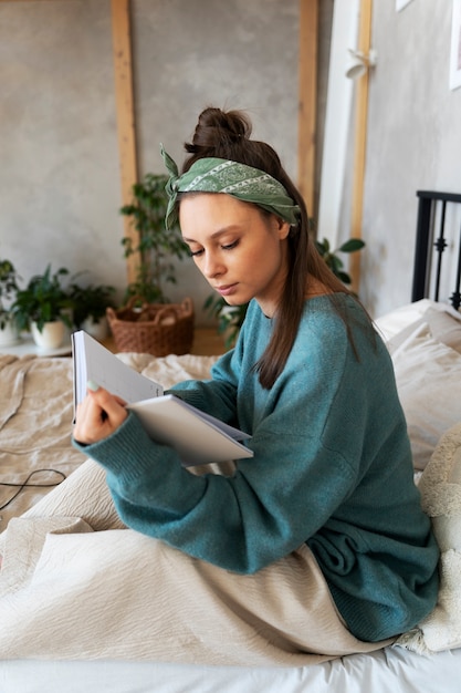 Gratis foto jonge vrouw met rommelig broodje thuiswerkend