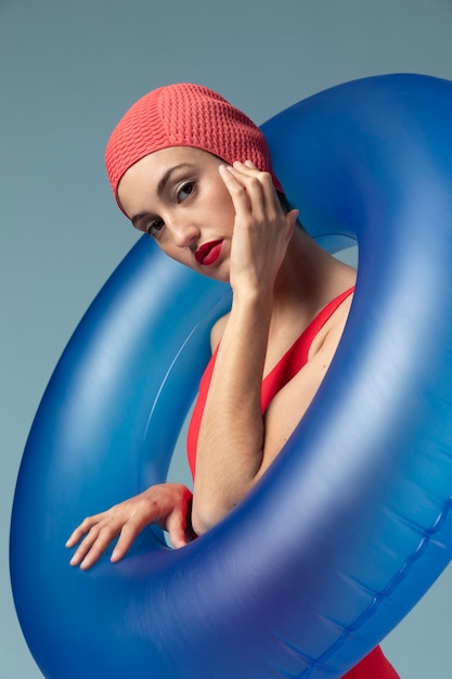 Jonge vrouw met rood zwempak en een zwemmende ring