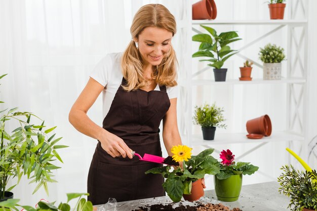 Jonge vrouw met schort in kas