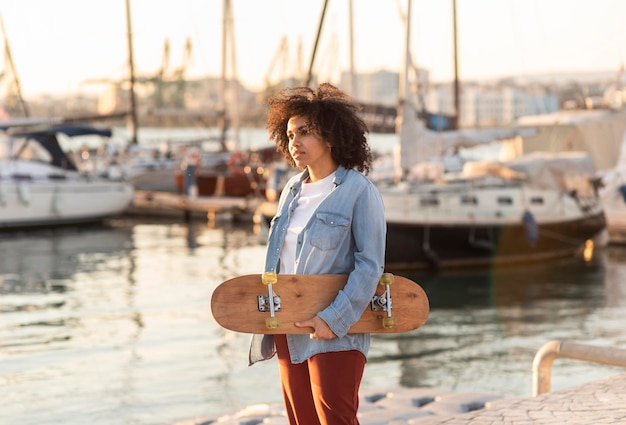 Gratis foto jonge vrouw met skateboard