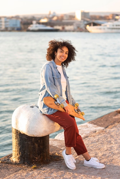 Gratis foto jonge vrouw met skateboard